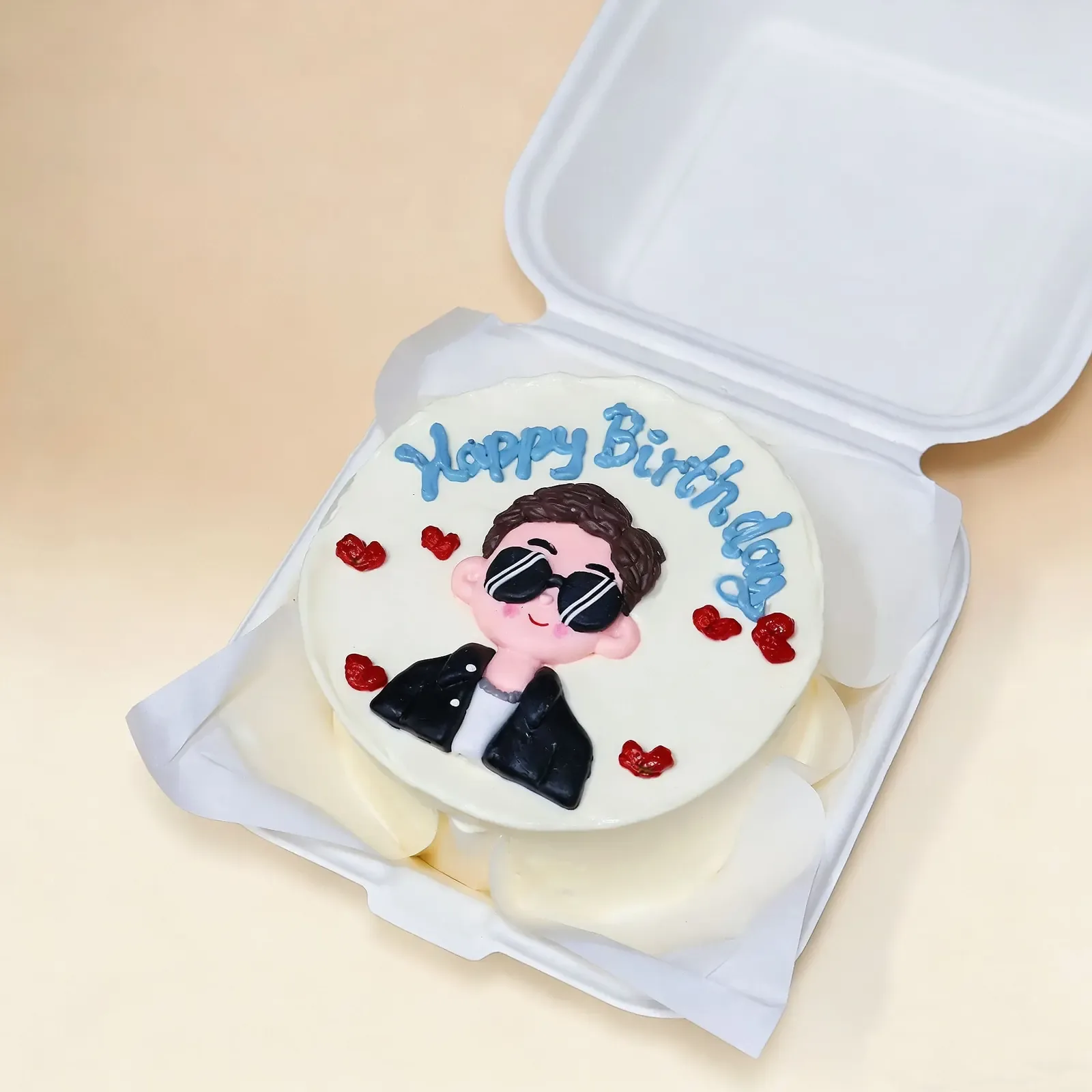 Custom birthday cake with cartoon character, hearts, and blue Happy Birthday text in white box