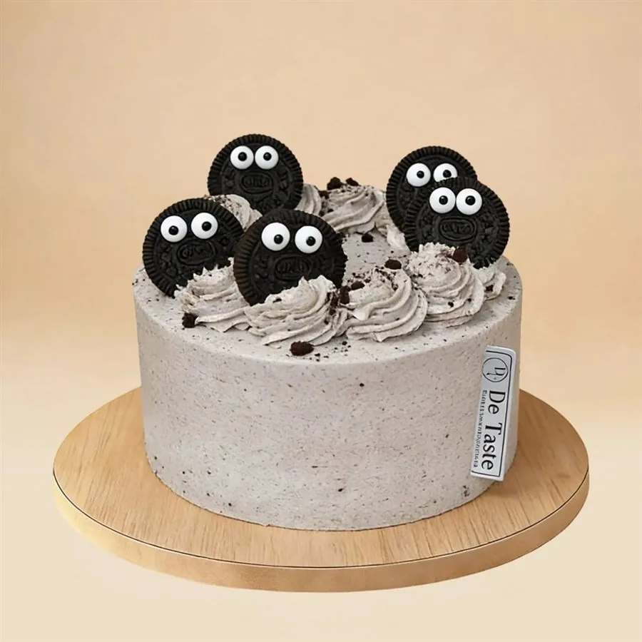 Decorated cake with cookie faces and cream swirls on wooden board