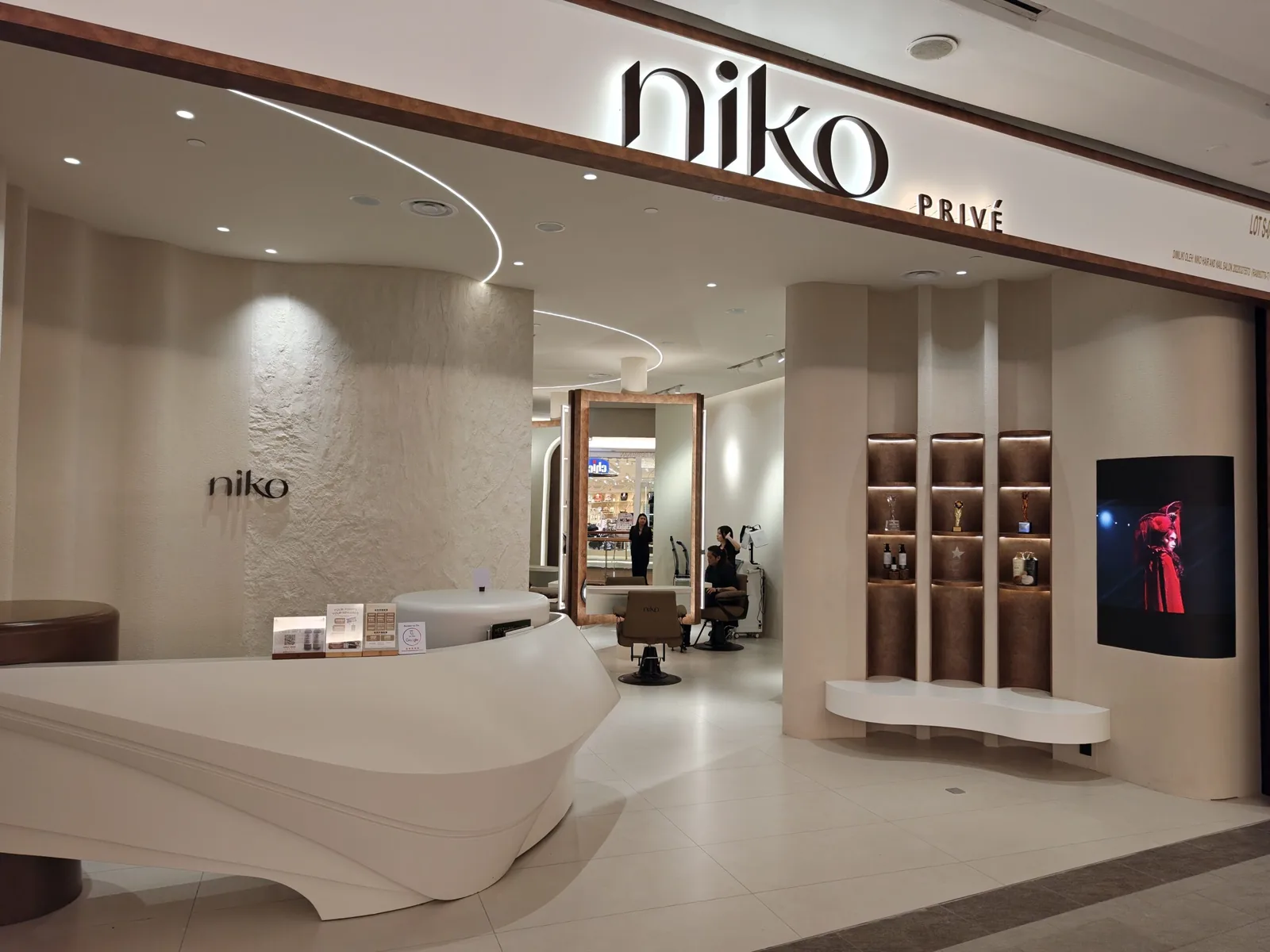 Modern spa storefront with white reception desk and product display shelving