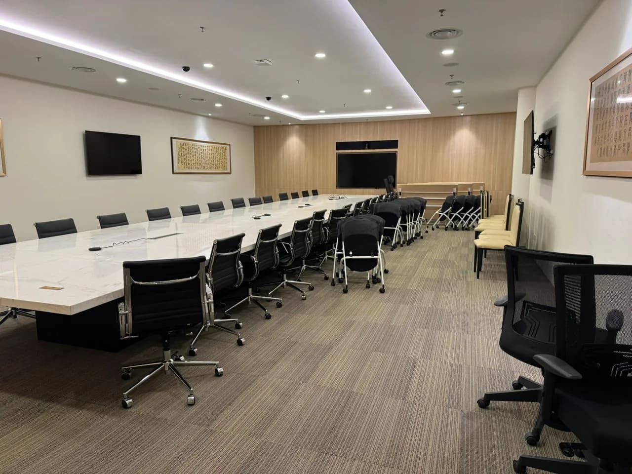 Modern conference room with long table, black chairs, and professional lighting