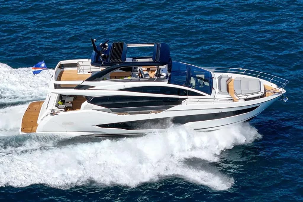 Luxury motor yacht with white hull and blue accents cruising through ocean waves