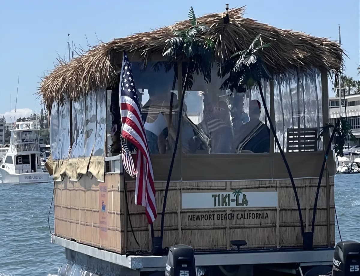 Tiki-style party boat with palm-thatched roof on Newport Beach harbor water
