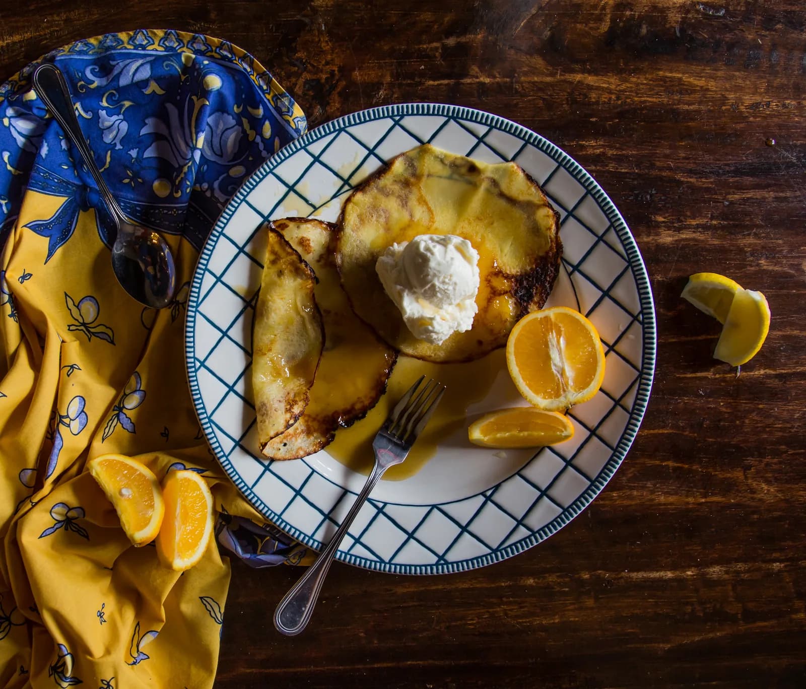 Caramelized bananas with whipped cream and orange garnish on decorative plate