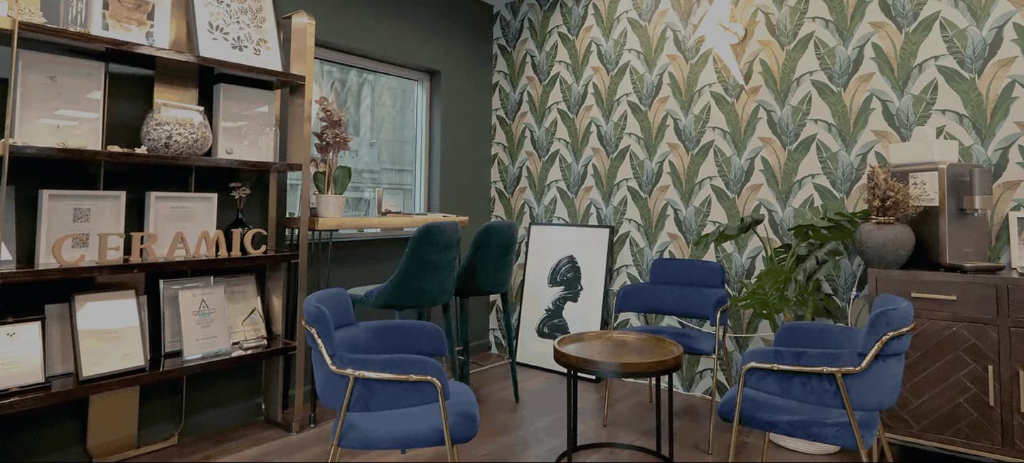 Dental clinic waiting room with blue chairs, patterned wall, and display shelving.