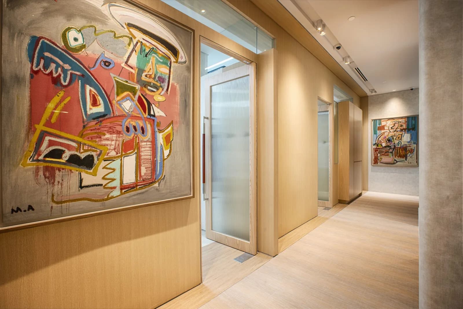 Modern dental clinic corridor with framed abstract artwork and frosted glass room dividers