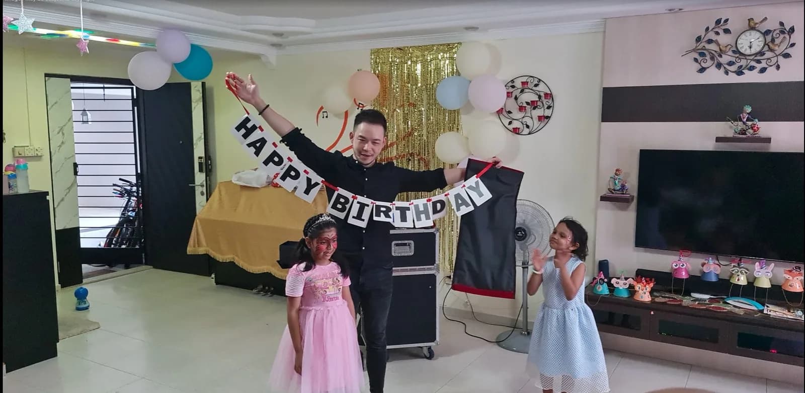 Party planner with children in decorated birthday party venue with banners and balloons