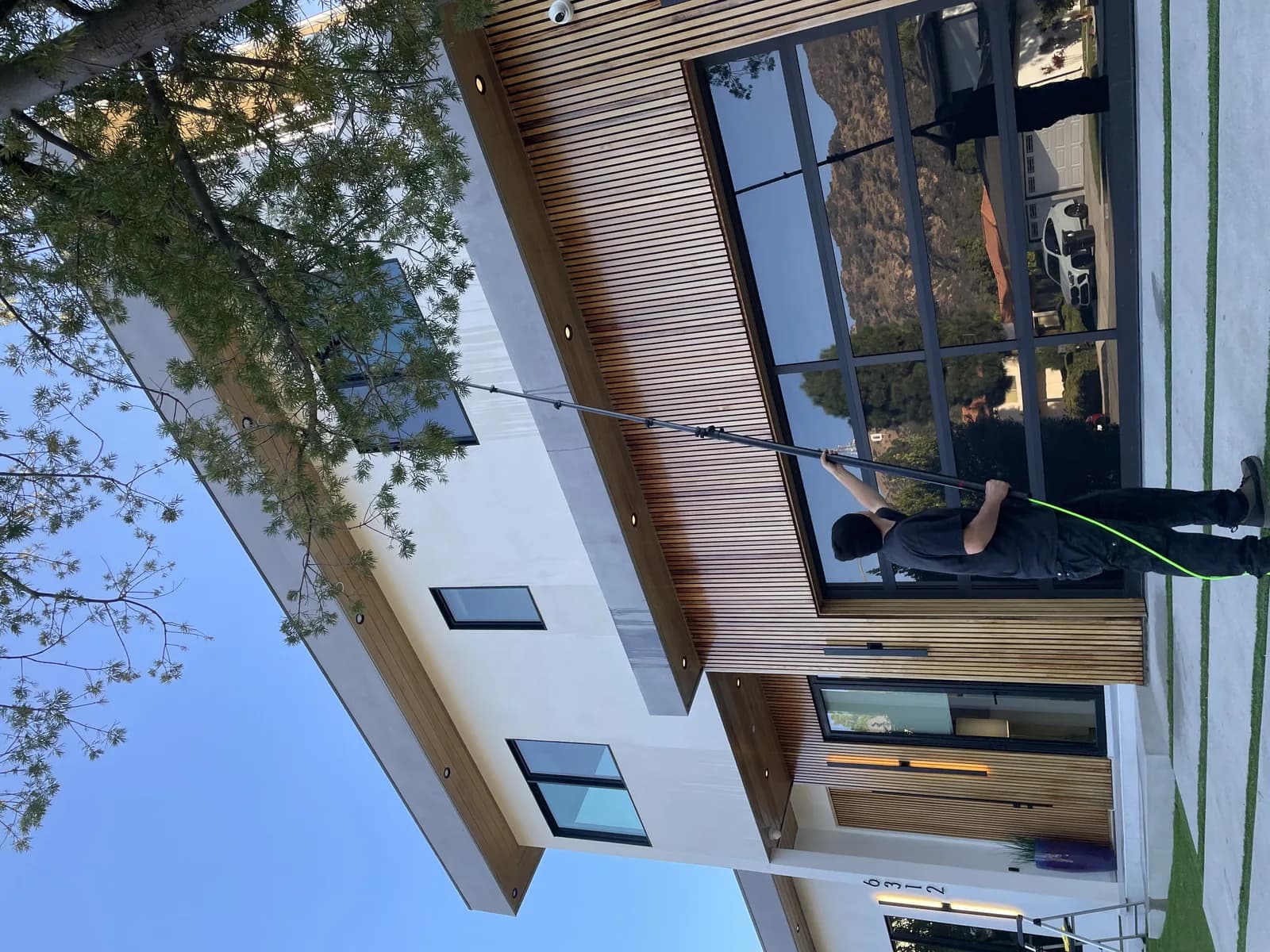 Worker cleaning building exterior windows and gutters with professional tools