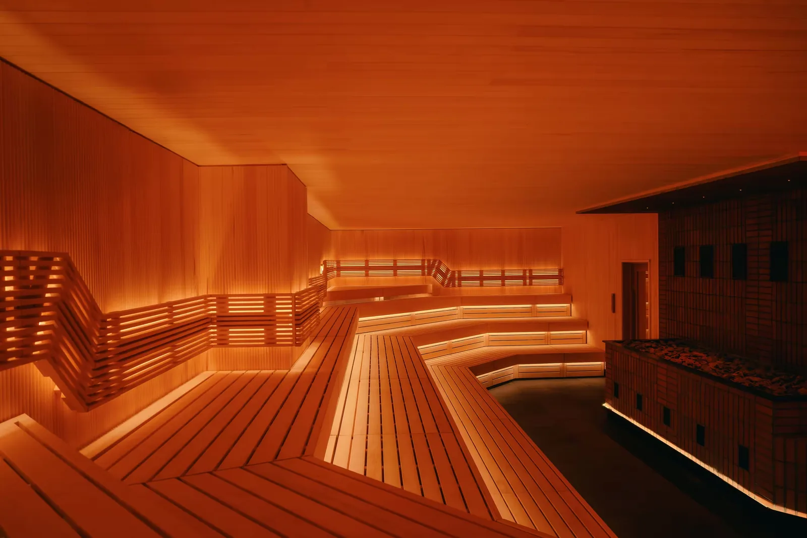 Wooden sauna interior with tiered benches and warm ambient lighting