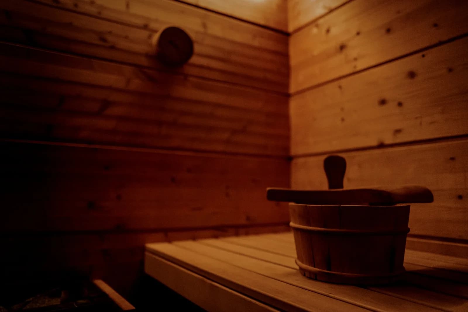 Wooden sauna interior with benches and traditional buckets with ladles