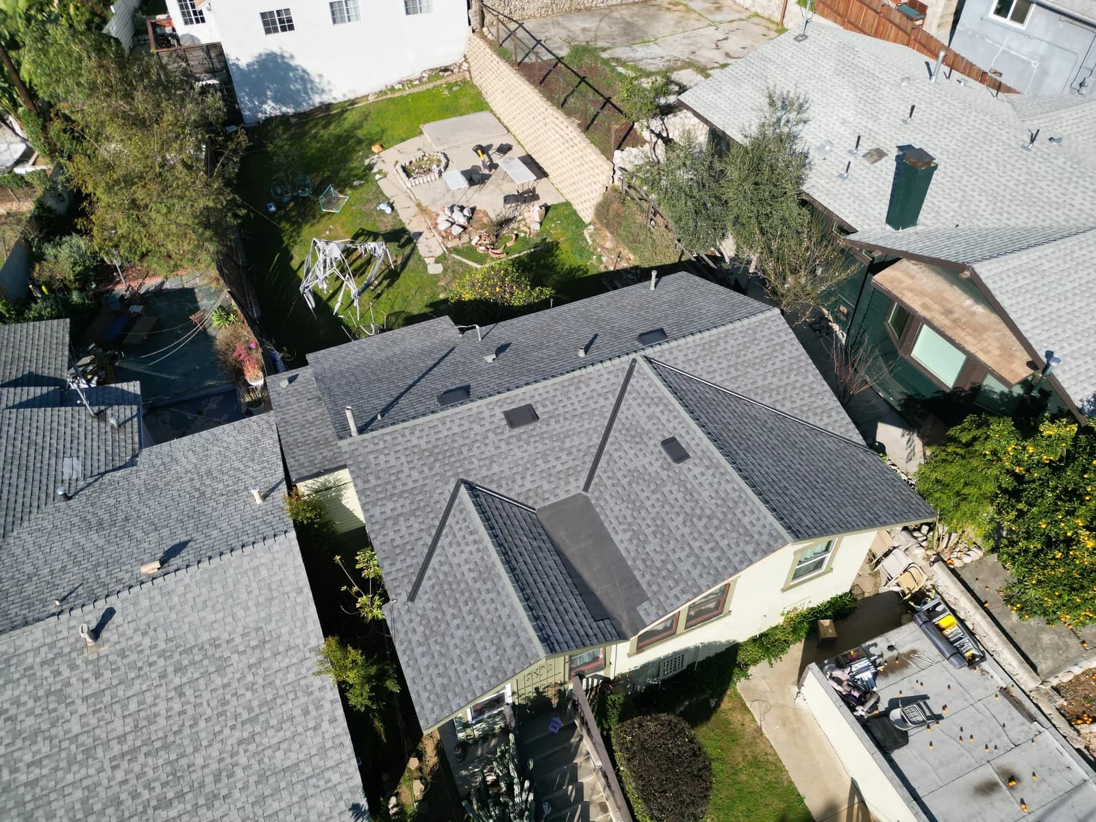 Aerial view of a residential home with newly installed gray asphalt shingle roofing