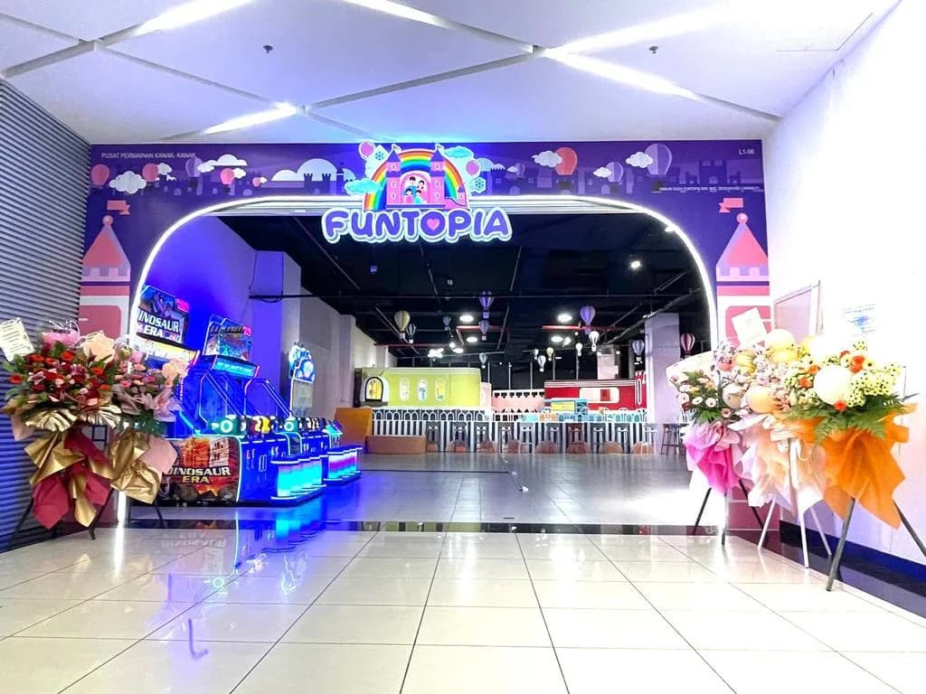 Entrance to Puntopia entertainment venue with neon signage and colorful floral decorations.