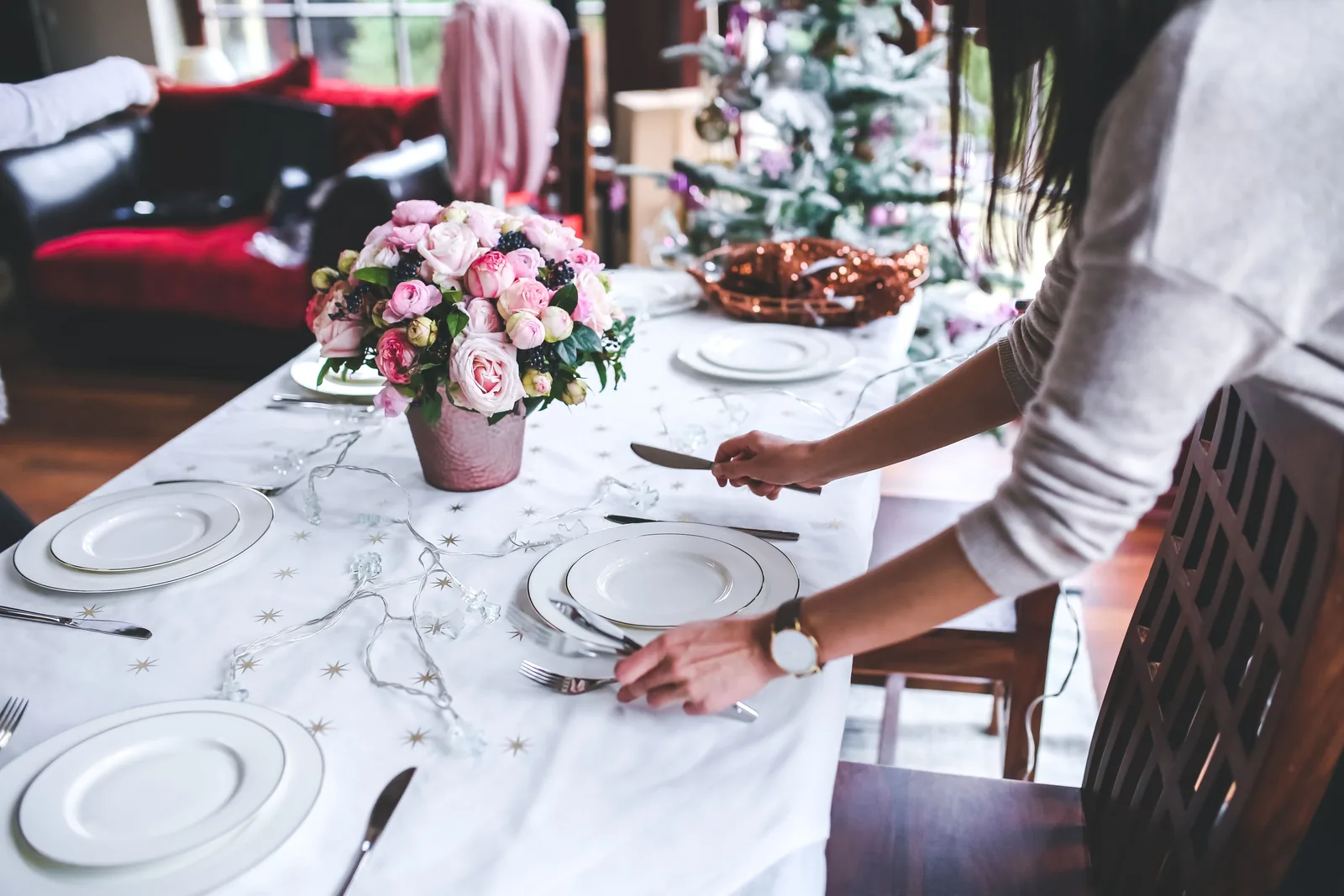 Elegant table setting with pink flowers, white plates, and linens at an event venue