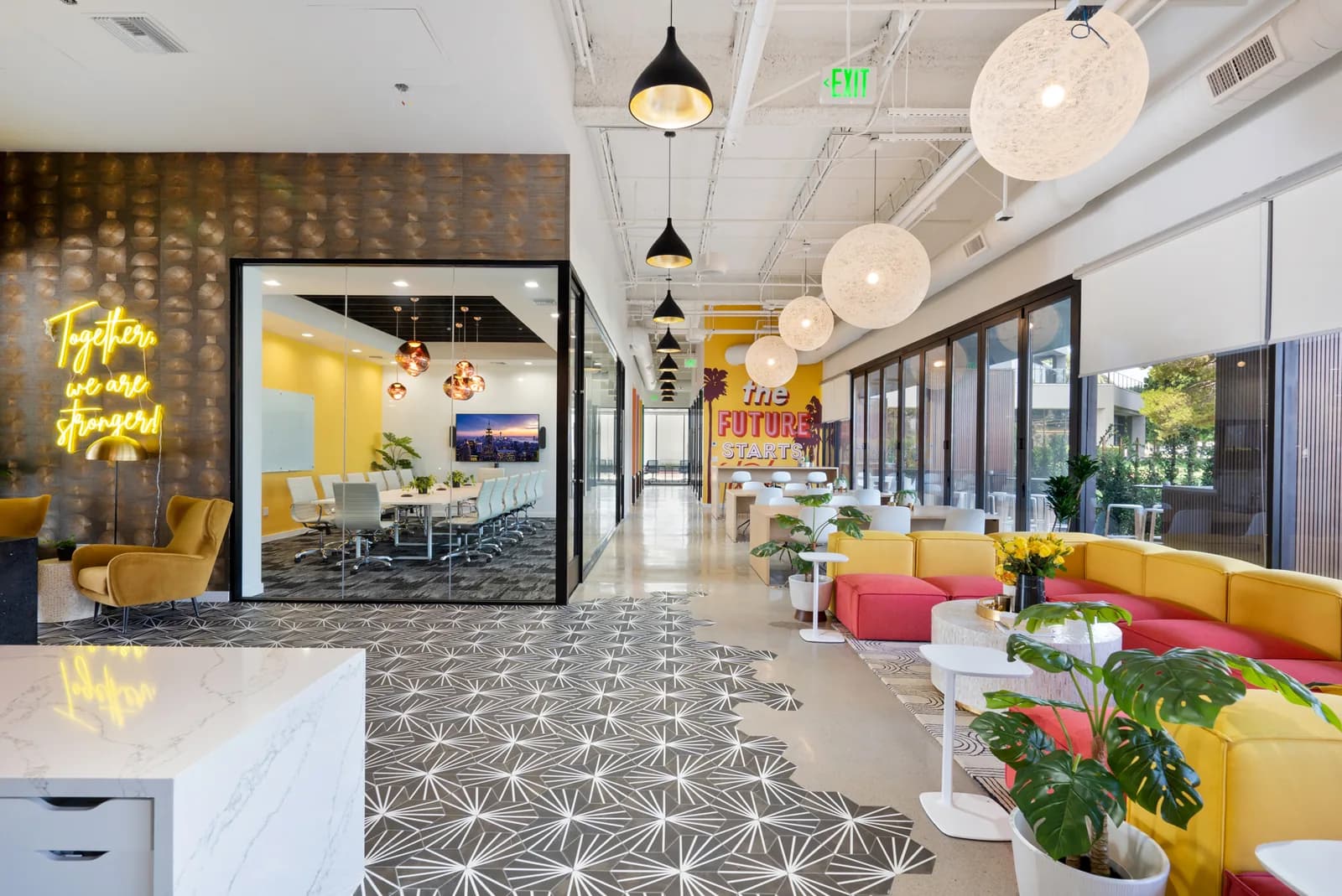Modern open-plan event space with colorful seating, geometric floors, and bright natural lighting