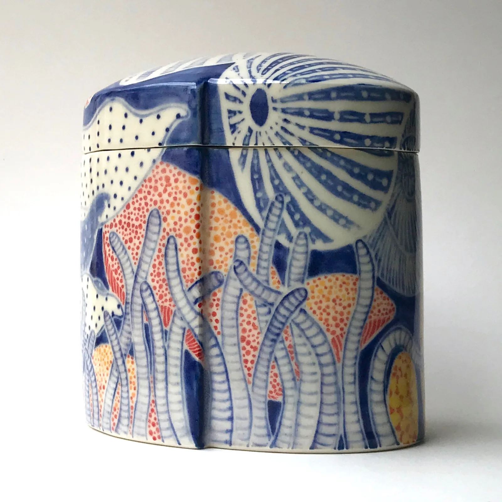 Decorative ceramic jar with blue and orange hand-painted floral patterns and fitted lid