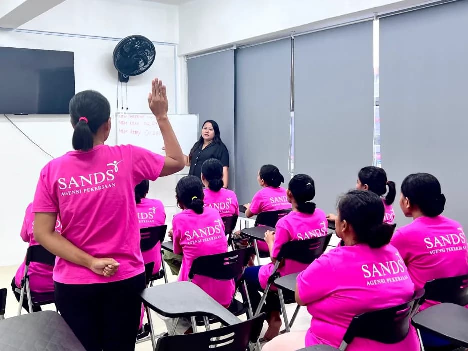 Staff training session with employees in pink SANDS agency shirts in a classroom setting