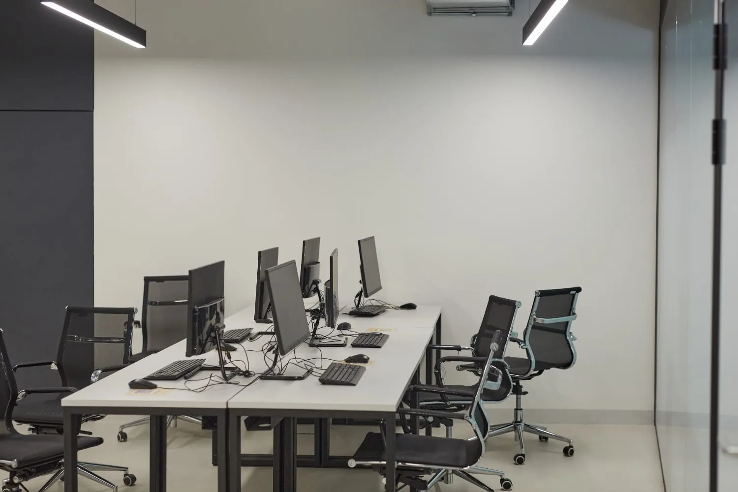 Modern office workspace with computer workstations and black office chairs