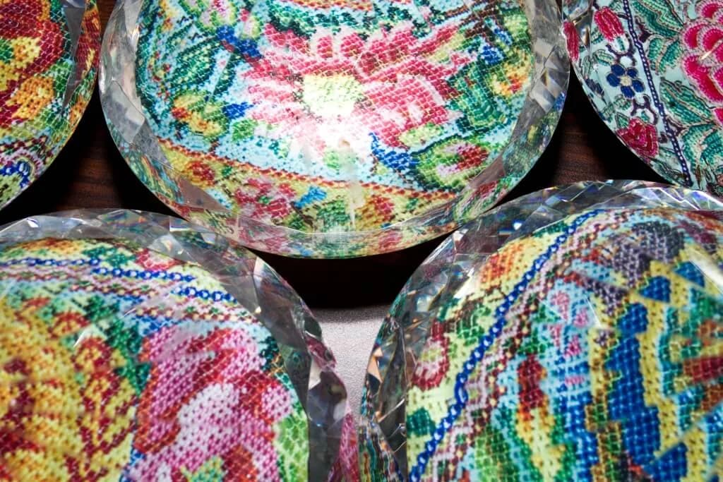 Rolls of colorful patterned fabric with blue, pink, yellow, and green geometric designs