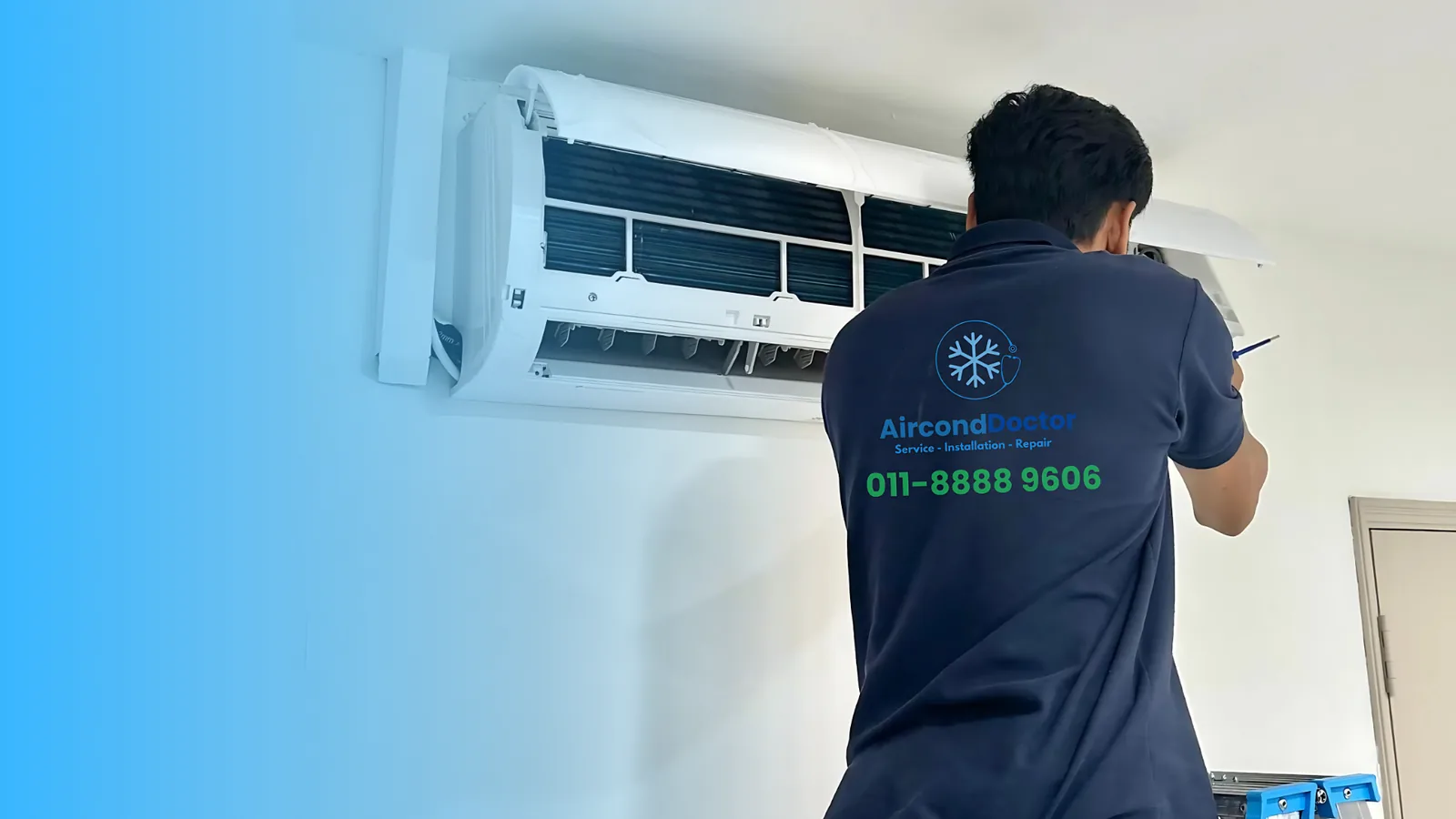 Technician servicing wall-mounted air conditioner unit indoors